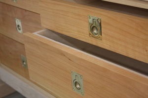 Cherry drawer fronts featuring brass ring pulls